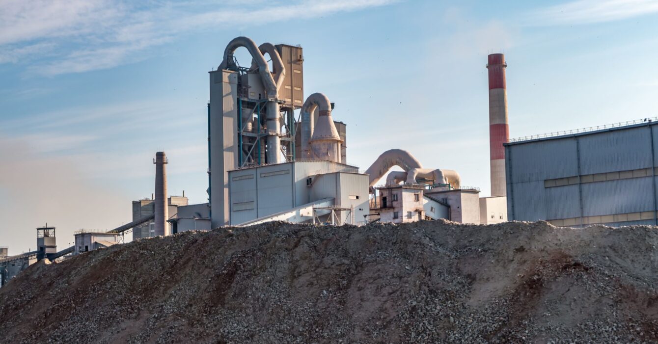 Industrial grey landscape environmental pollution waste of cement factory. Big pipes of industry enterprise plant. mountains of sand and rubble Industrial grey landscape environmental pollution waste of cement factory. Big pipes of industry enterprise plant. mountains of sand and rubble